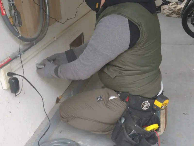 Electrician performing outlet wiring in a Welcome garage